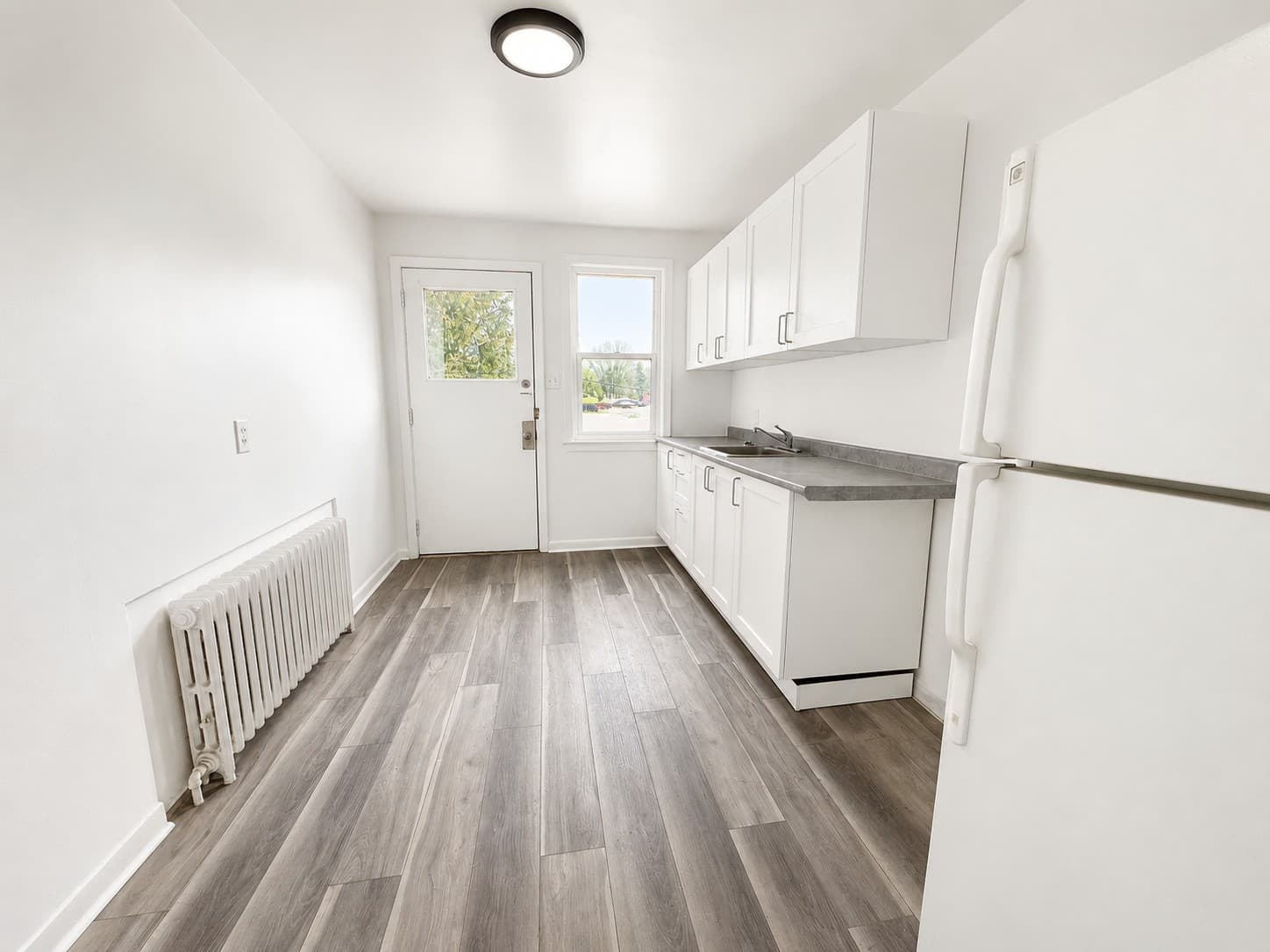 Clarence Apartments — white kitchen with radiator