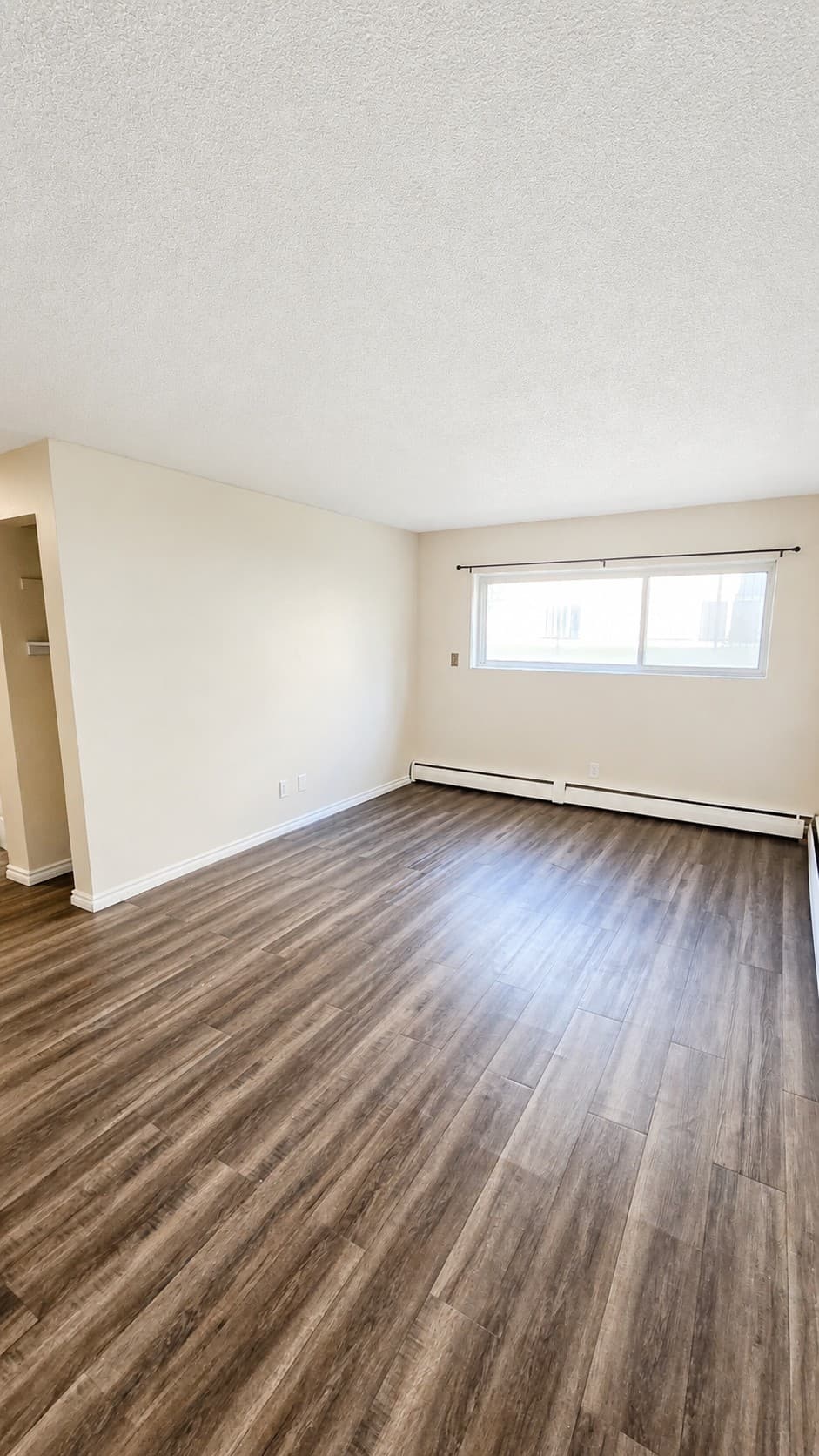 Dakota Apartments — bright living room with wood flooring