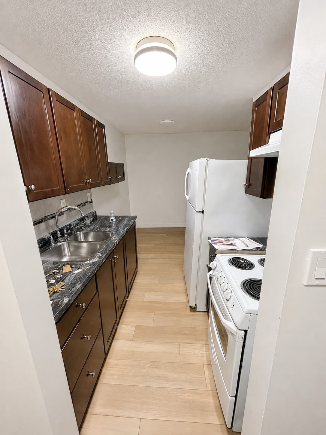 Westlynn Apartments — renovated kitchen with dark wood cabinets